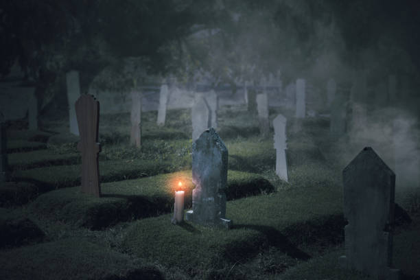 istock Tombstones with candles on the graveyard 1353558578