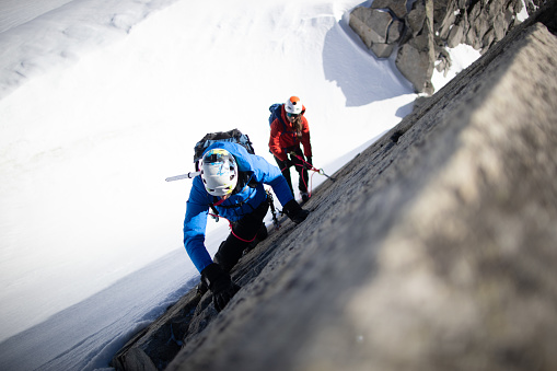 Two people climbing on a mountain.