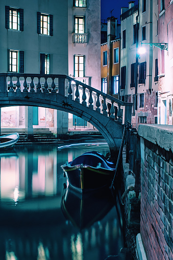 Traditional venetian bridge and view of Venice by night with long exposure
