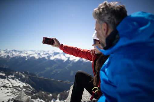 Two climbers taking a selfie on top of a mountain.
