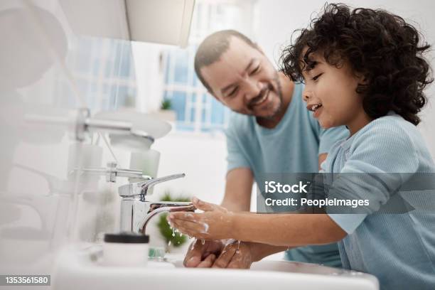 Shot Of A Father Helping His Son Wash His Hands And Face At A Tap In A Bathroom At Home Stock Photo - Download Image Now