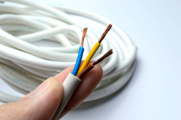 istock a stripped three-wire electric wire in a hand against the background of a wire twisted into a bobbin. 1353565509
