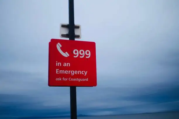 999 emergency sign for the coastguard. Captured on Prestwich Beach in Scotland