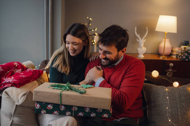 istock Young couple gives each other Christmas presents 1353569062