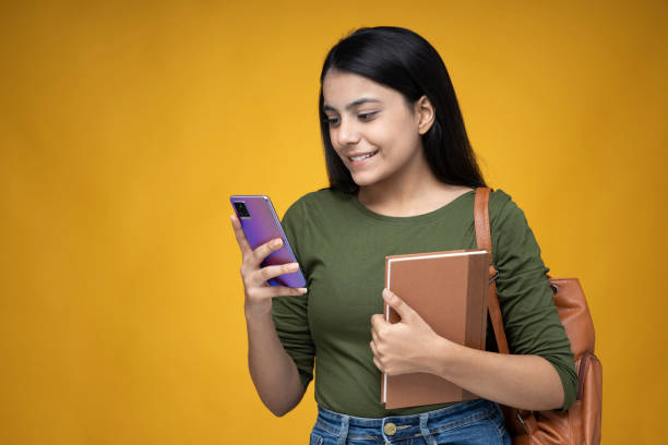 黄色のコピースペースの背景ストック写真に若いインドの女性 - teenager smart phone young women teenagers only ストックフォトと画像