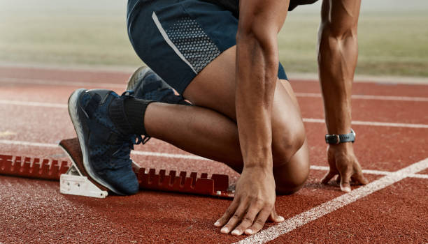 photo d’un athlète masculin attendant sur la ligne de départ pour commencer une course - ligne de départ photos et images de collection