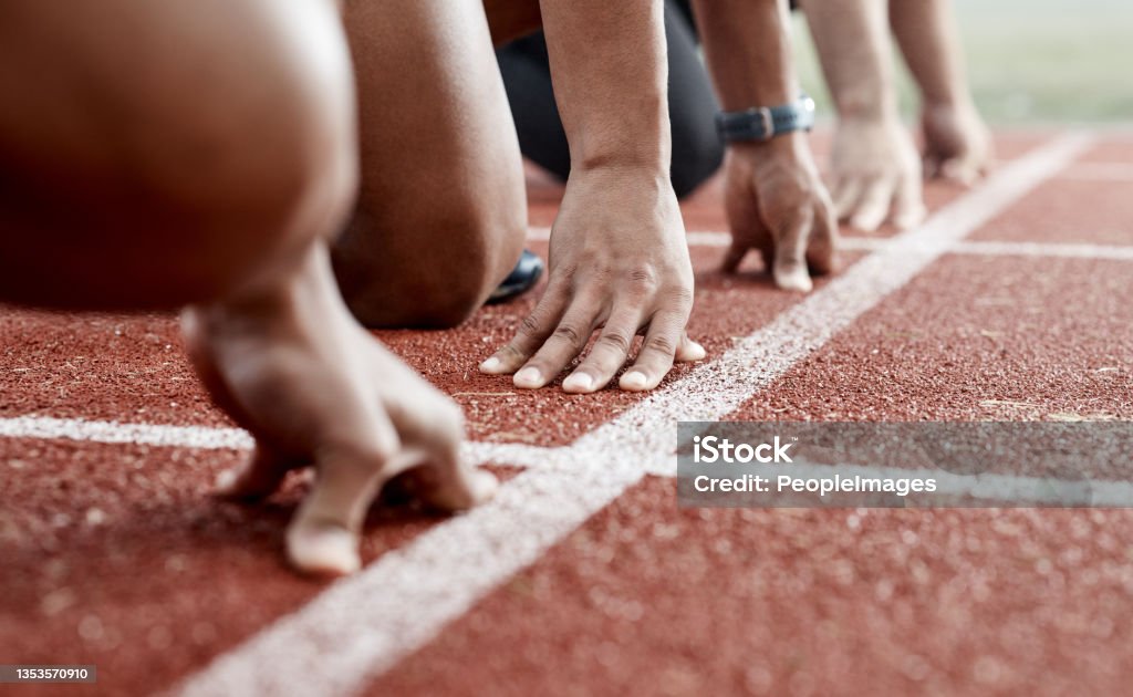 Shot of a group of athletes ready to start a race Runners take your places Beginnings Stock Photo