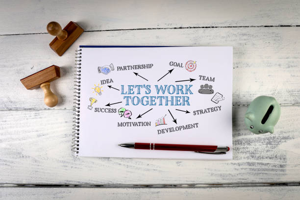 istock Let's work together. Notebook on a white wooden office desk 1353575734
