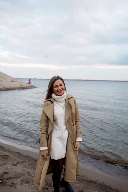 istock Young woman walking on the beach in autumn 1353575849