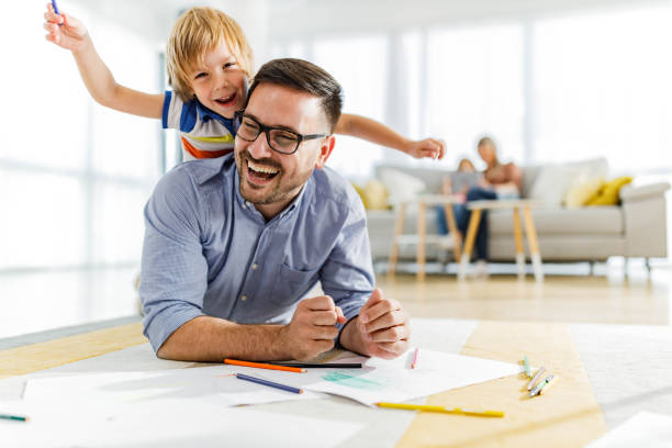 istock Playful father and son having fun on floor at home. 1353575921