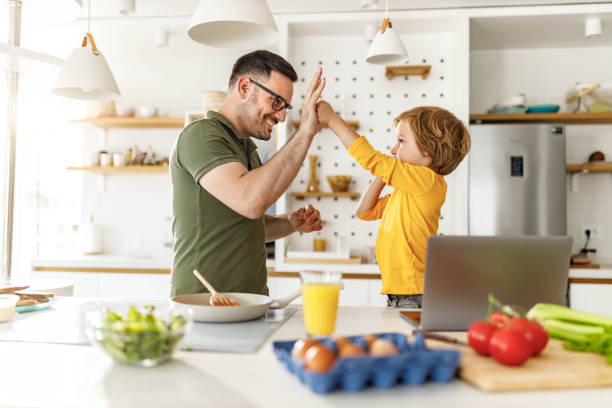 istock Happy single father and son having fun in the kitchen. 1353575947