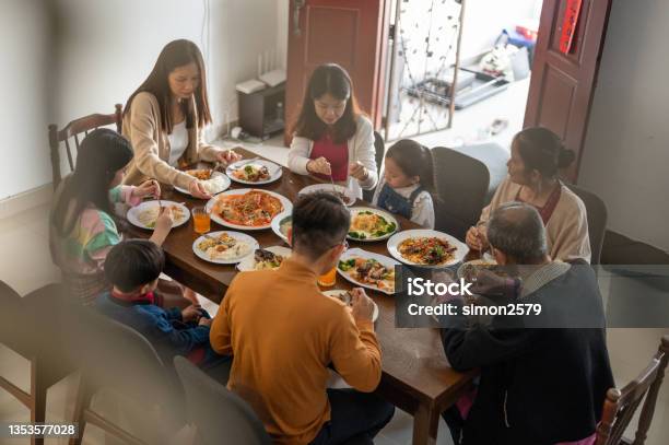 Three Generations Of Joyful Asian Family Celebrating And Enjoying Reunion Dinner At Home During Chinese New Year Stock Photo - Download Image Now