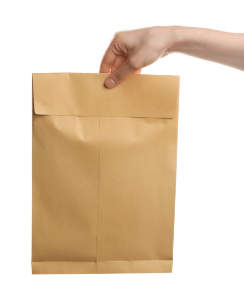 istock Woman holding kraft paper envelope on white background, closeup 1353577699