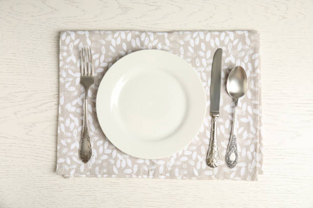 istock Empty plate, cutlery and napkin on white wooden table, flat lay 1353577776
