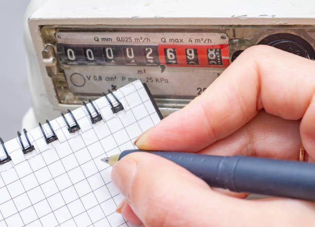 woman with pen and notepad writes the natural gas meter readings. - boiler power station fuel and power generation gas boiler imagens e fotografias de stock