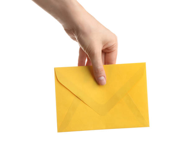 istock Woman holding yellow paper envelope on white background, closeup 1353578525