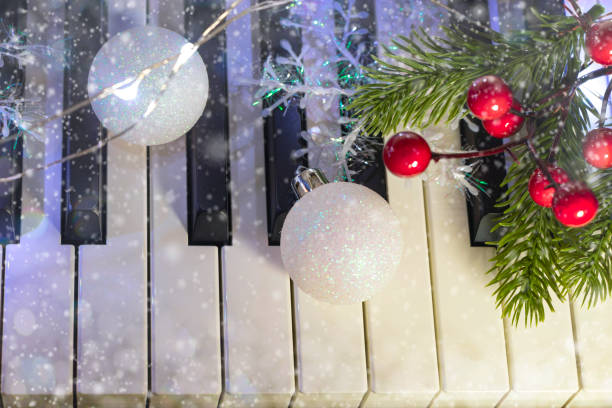 flat lay of piano with white christmas balls and branch of christmas tree on bokeh background. New Year or Christmas music concept stock photo