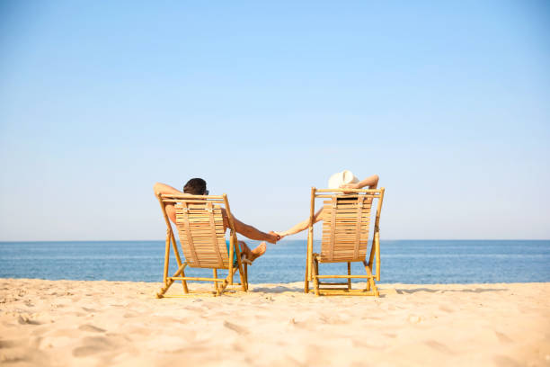istock Couple resting on sunny beach at resort 1353578799