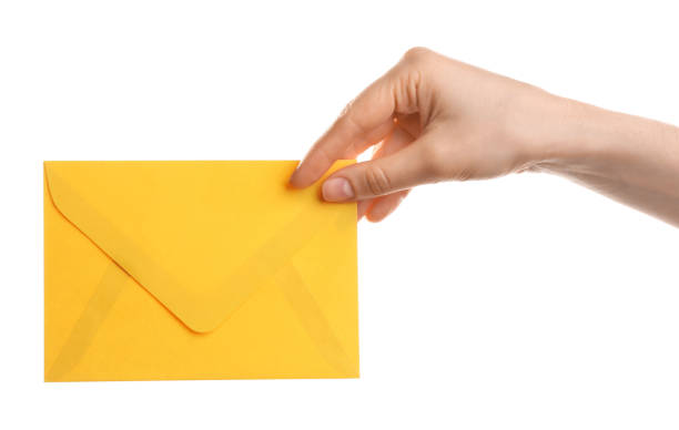 istock Woman holding yellow paper envelope on white background, closeup 1353579096
