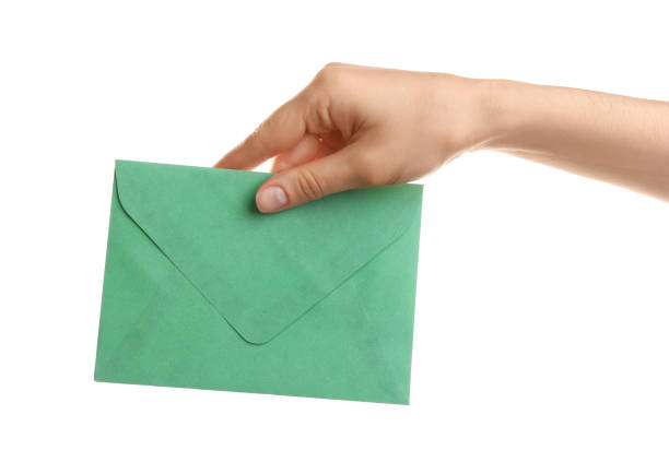istock Woman holding green paper envelope on white background, closeup 1353579120