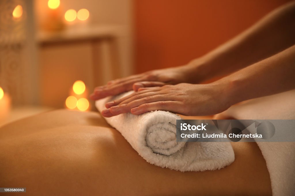 Young woman receiving hot towel massage in spa salon, closeup Massaging Stock Photo