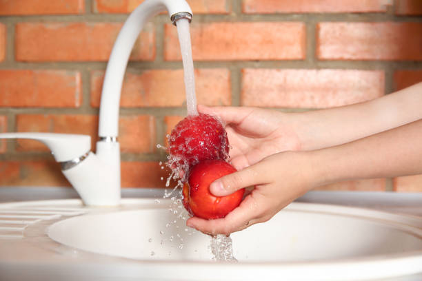 istock Woman washing fresh nectarines in kitchen sink, closeup 1353580559