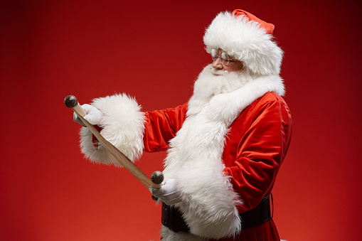 Christmas Santa Claus holds in his hands a list of names of good and bad children