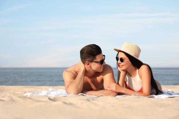 istock Happy couple resting on sunny beach. Space for text 1353581746