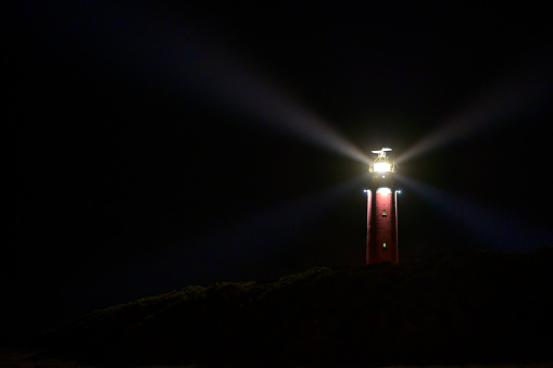 Lighthouse at the Wadden island Texel in the dunes at night with a footpaht leading up to the lighthouse.