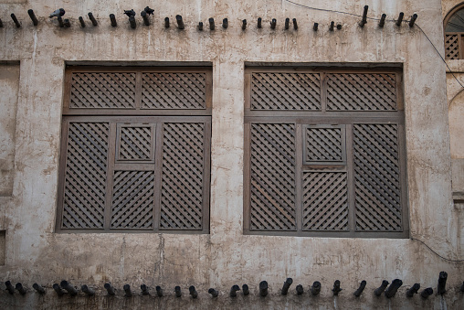 Doha,Qatar,05,10,2019. Old wooden windows in Arabic style on a traditional mud building in the market Souk Waqif.