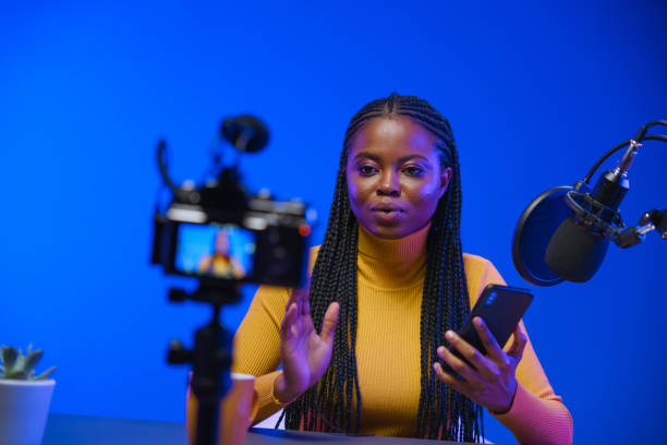 istock A young dark-skinned blogger telling a story on camera in a professional studio with blue background 1353589902