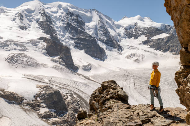 junge frau auf klettersteig in der nähe von gletscher schaut auf blick - engadine switzerland europe clear sky stock-fotos und bilder