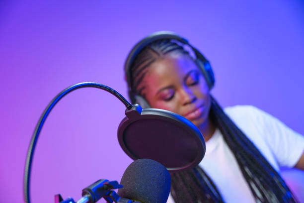 istock Young lady in front of studio microphone 1353591781