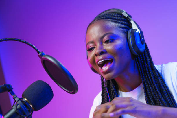 istock Young happy lady in front of studio microphone 1353591795
