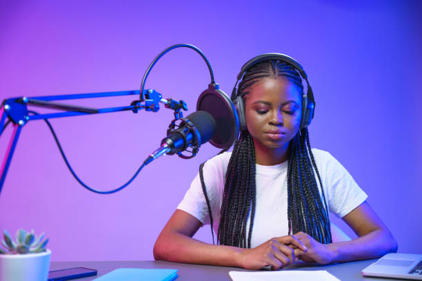 istock A young dark-skinned journalist, during the record in a professional recording studio with purple background 1353592011