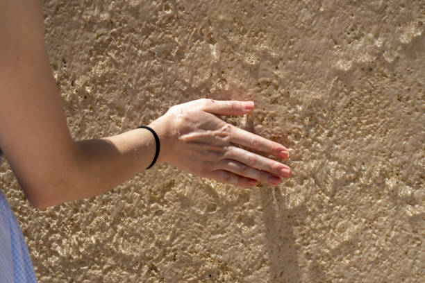 istock Woman hand on wet wall 1353592285