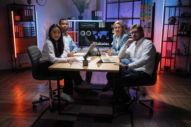 istock Diverse economists sitting at desk with modern gadegts 1353593013