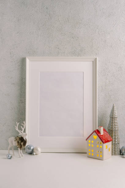 istock Christmas composition of Christmas decorations, pine branches, House lantern and a white mock up poster frame for presentation of works and text. Template. 1353594600