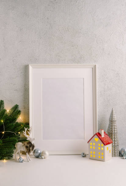 istock Christmas composition of Christmas decorations, pine branches, House lantern and a white mock up poster frame for presentation of works and text. Template. 1353594713