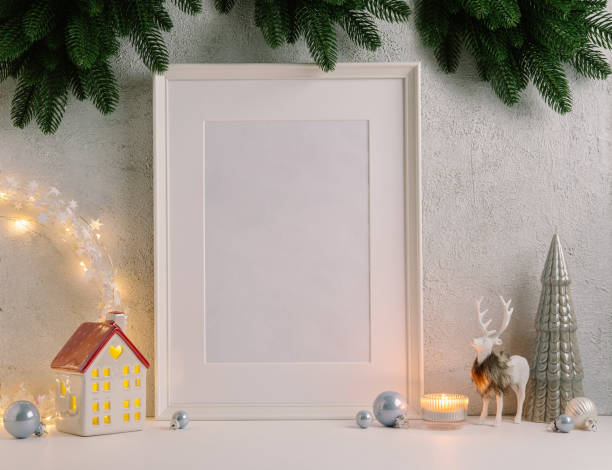 Christmas composition of Christmas decorations, pine branches, House lantern and a white mock up poster frame for presentation of works and text. Template.