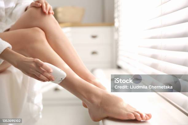 Woman Doing Leg Epilation Procedure Near Window Indoors Closeup Stock Photo - Download Image Now