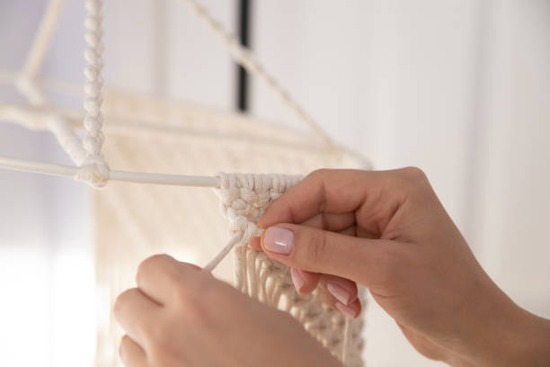 istock closeup weaving of macrame threads , women's hands 1353595348