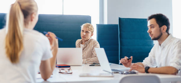 istock Group of people confer at work sitting at desk 1353596013