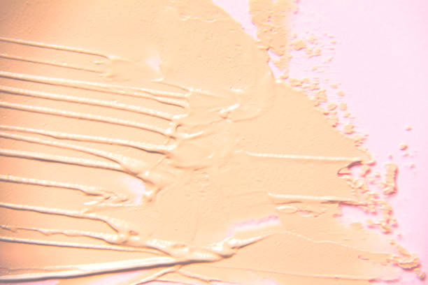 istock Beige foundation smear in blur on a pink background. 1353596224