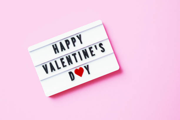 istock Happy Valentine's Day Written White Lightbox Sitting On Pink Background 1353596537