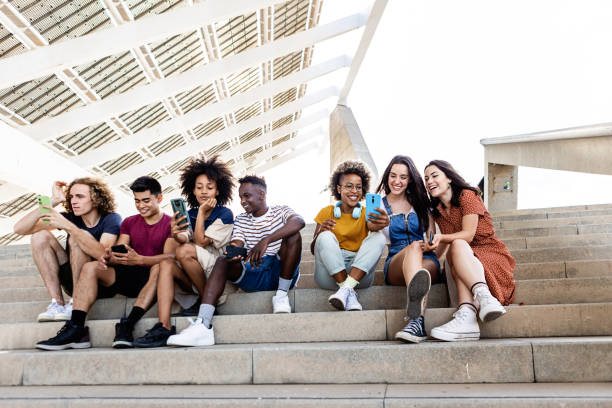 istock Group of diverse hipster friends students using mobile phone outdoors 1353597323