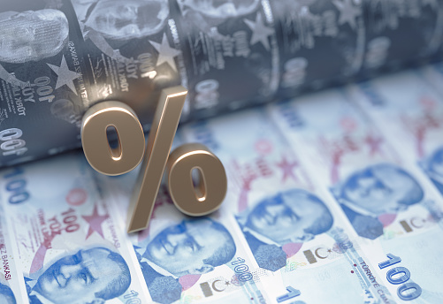 Signo de porcentaje de color dorado sobre los billetes de liras turcas - Concepto de mercado de valores y finanzas photo
