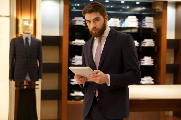 istock Businessman with tablet in wardrobe 1353600024