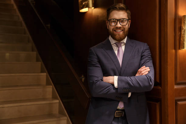 istock Happy young bearded businessman standing indoors 1353600410