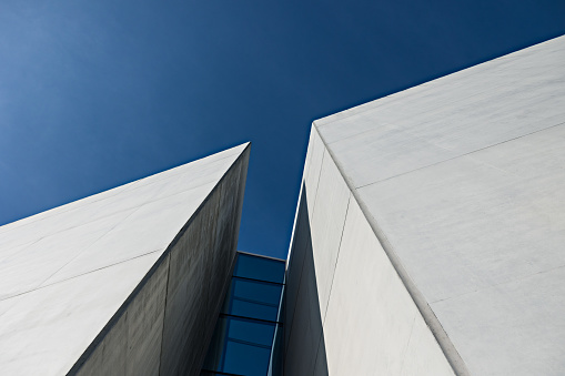 Abstract modern architecture details, urban facade made of steel framework and shiny glass is under blue sky